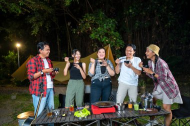 Endonezya 'nın güneydoğusundaki Asyalılar yemek yiyorlar, yemek çubuklarını kullanarak kendilerine küçük siyah kaselerden ızgara yemek servis ediyorlar. Doğal ortamdaki yemekten zevk alma sahnesi.