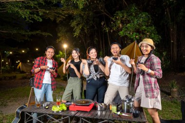 Endonezya 'nın güneydoğusundaki Asyalılar yemek yiyorlar, yemek çubuklarını kullanarak kendilerine küçük siyah kaselerden ızgara yemek servis ediyorlar. Doğal ortamdaki yemekten zevk alma sahnesi.