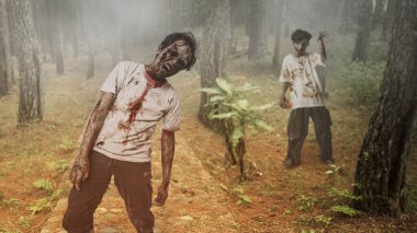 Yaralı ve kanlı korkunç erkek zombiler perili ormanda yürüyorlardı. Sahne korkutucu ve ürkütücü. Dramatik duman ya da sis etkisi. Ürkütücü Cadılar Bayramı kavramı