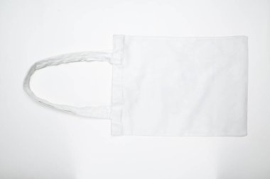 Beyaz bir arka planda, çevre dostu beyaz pamuk tuval çantasının üst görüntüsü. Model, şablon veya kopyalama alanı. Bakkaliye ve alışveriş için tekrar kullanılabilir çanta