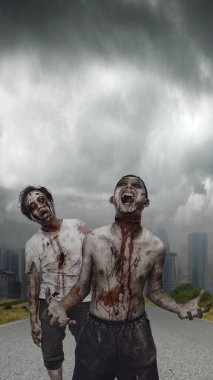 Endonezya 'nın güneydoğu Asya kökenli, yaralı ve kanlı korkunç erkek zombiler karanlık bulutlu bir gökyüzünün altında kıyametin ortasında yürüyorlardı. Sahne korkutucu ve ürkütücü. Ürkütücü Cadılar Bayramı kavramı