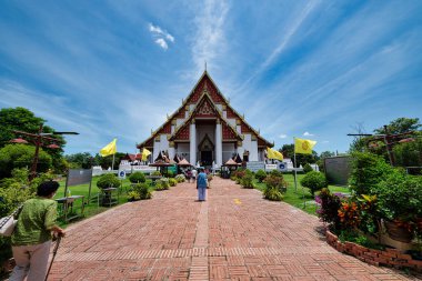 Açıklama: Tayland 'ın Ayutthaya kentindeki huzurlu Wat Phra Mongkhon Bophit tapınağı kompleksi içinde uzanan devasa Buda heykelinin görkemli manzarası. Buda 'nın dingin ifadesi ve heykelin karmaşık ayrıntıları tuhaf bir his uyandırıyor.