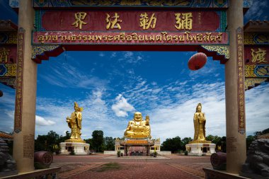 Chachoengsao, Tayland, Haziran 04, 2024, Wat Cheen Pracha Samosorn (Wat Leng Hok Yi), Tayland Altın Üçlü Tapınağı. Bereketli yeşillik ve açık mavi gökyüzü ile çevrili üç altın heykelin yer aldığı huzurlu ve görkemli bir Budist tapınağı. Tapınak kapısı.