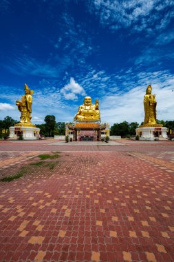 Chachoengsao, Tayland, Haziran 04, 2024, Wat Cheen Pracha Samosorn (Wat Leng Hok Yi), Tayland Altın Üçlü Tapınağı. Bereketli yeşillik ve açık mavi gökyüzü ile çevrili üç altın heykelin yer aldığı huzurlu ve görkemli bir Budist tapınağı. Tapınak kapısı.