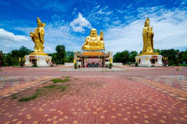 Chachoengsao, Thailand, June 04, 2024, Wat Cheen Pracha Samosorn (Wat Leng Hok Yi), Golden Trio Shrine in Thailand. A serene and majestic Buddhist shrine featuring three golden statues, surrounded by lush greenery and a clear blue sky. The shrine exu clipart