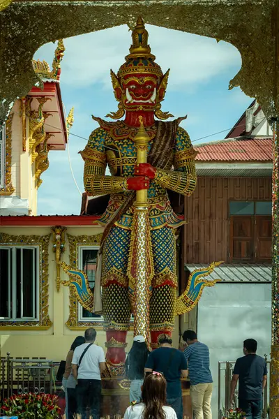 stock image Chachoengsao, Thailand, June 04, 2024, Wat Chuk Krachoe, Giant Guardian Statue in Temple.  A majestic guardian statue stands tall in front of a traditional Thai temple, showcasing intricate details and vibrant colors against a clear blue sky. The sta