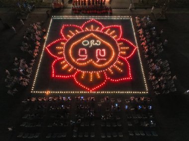 Lopburi Puttha Sathan festivali sırasında geniş bir çiçek deseni oluşturan karmaşık ışık dizilimi seyircilerden oluşan bir kalabalığın ilgisini çekiyor ve canlı bir atmosfer yaratıyor..