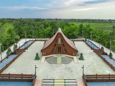 Wat Pa Thammawisut Mongkhon Tapınağı 'na gelen ziyaretçileri karşılayan sakin çevrede Lopburi, Tayland' da berrak bir gökyüzü altında yemyeşil ve bakımlı alanlar yer almaktadır..