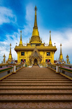 Nakhon Sawan 'daki Wat Khiriwong altın kuleleri ve süslü süslemeleriyle ışıldıyor. Ziyaretçiler, Kasım ayında canlı bir gökyüzü altındaki görkemli yapıya hayran kaldılar..