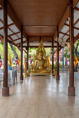 Nonthaburi 'deki Wat Chomphuwek' te altın bir Buda heykeli sergilenmektedir. Geleneksel bayraklar, ziyaretçiler barışçıl bir şekilde yaklaşırken dalgalanıyor.