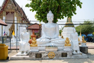 Ziyaretçiler, Tayland 'ın Nonthaburi kentindeki Wat Chimphli Sutthawat kentindeki beyaz Buda heykellerine hayranlık duyarken, güneşli bir Mart gününde huzurlu bir atmosferin keyfini çıkarıyorlar..