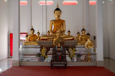 Ziyaretçiler, Wat Na Tang Nok 'ta bulunan ve Phra Nakhon Si Ayutthaya, Tayland' daki sakin atmosferin keyfini çıkarırken küçük figürlerle çevrili büyük altın Buda heykeline hayran kaldılar..