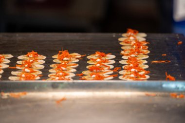 Tedarikçiler, akşam karanlığında canlı bir pazar atmosferinde ince kırmızı iplikçikler ve diğer taze malzemelerle dolu canlı yemekleri ustaca hazırlıyorlar..