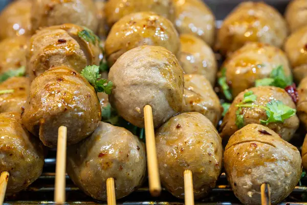 Ahşap şişler üzerindeki tuzlu köfteler hareketli bir sokak yiyecek pazarında cızırdıyor. Etrafı otlar ve baharatlarla çevrili. Akşam havasında nefis bir koku yaratıyor..