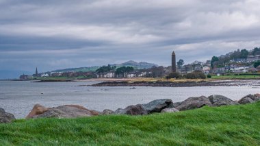 The town of Largs set on the Firth of Clyde on the West Coast of Scotland. Looking from the marina into the town past the Pencil monument on a cold day. Knock Hill in the far distance.