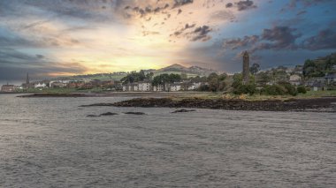 Scottish Town of largs Looking North Past the Pencil Monument with the sun going down behind Knock Hill in the far Distance.