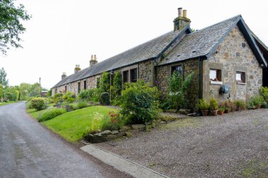 St Andrews, İskoçya, İngiltere - 11 Temmuz 2024: St Andrews dışındaki İskoç stili taştan kulübeler çiçek çitleri ve çakıllı garaj yolları.