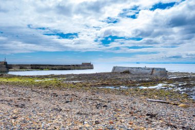 The distinctive lichen covered rocks that form part of the ancient sea defences on St Monans shore line and harbour. clipart