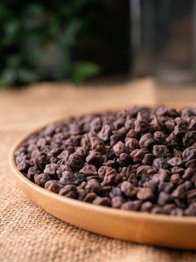 Kala Chana (Kala Chana) sade ahşap bir masa üzerinde çiğ Koyu Kahverengi Nohut. Kuru Balck nohutu (ceci neri) arkaplanı kapat.