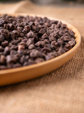 Kala Chana (Kala Chana) sade ahşap bir masa üzerinde çiğ Koyu Kahverengi Nohut. Kuru Balck nohutu (ceci neri) arkaplanı kapat.