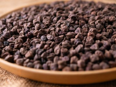 Kala Chana (Kala Chana) sade ahşap bir masa üzerinde çiğ Koyu Kahverengi Nohut. Kuru Balck nohutu (ceci neri) arkaplanı kapat.