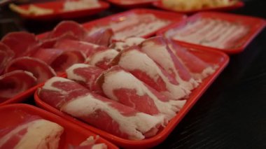 Restoran masasında Shabu ya da Sichuan güveci için dilimlenmiş et ve domuz eti..