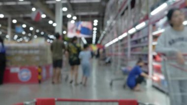 Modern süpermarket depolama arkaplanının bulanık görüntüsü. Odaklanmış bokeh ışığı arka planında hipermarket alışverişi.