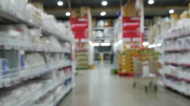 Modern süpermarket depolama arkaplanının bulanık görüntüsü. Odaklanmış bokeh ışığı arka planında hipermarket alışverişi.