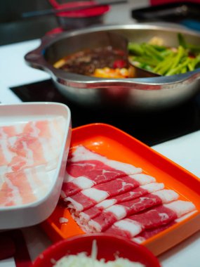 Restoran masasında Shabu ya da Sichuan güveci için dilimlenmiş et ve domuz eti..