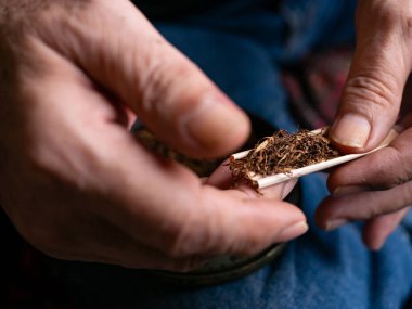 Kurutulmuş tütünle sarılmış sigara hazırlıyorum..