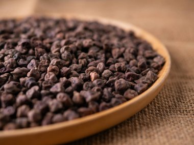 Kala Chana (Kala Chana) sade ahşap bir masa üzerinde çiğ Koyu Kahverengi Nohut. Kuru Balck nohutu (ceci neri) arkaplanı kapat.