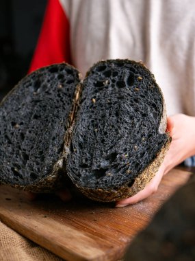 Baker Hand sunar ev yapımı taze pişmiş kömürlü ekşi ekmek. Kırıntılar içeride gösteriliyor