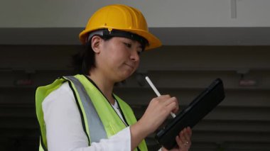 Fabrika kadın işçileri veya teknisyenleri İnşaat mühendisi veya Mimarlık proje yönetimi iş yerinde tableti kullanarak.