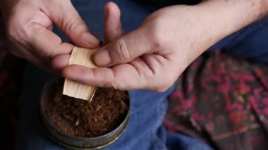 Kurutulmuş tütünle sarılmış sigara hazırlıyorum..