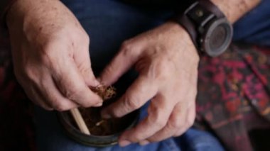 Kurutulmuş tütünle sarılmış sigara hazırlıyorum..