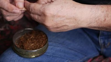 Kurutulmuş tütünle sarılmış sigara hazırlıyorum..