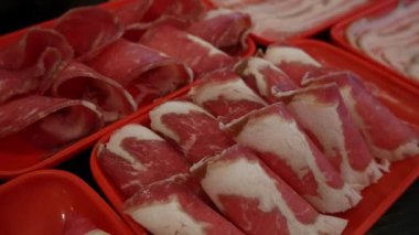 Restoran masasında Shabu ya da Sichuan güveci için dilimlenmiş et ve domuz eti..