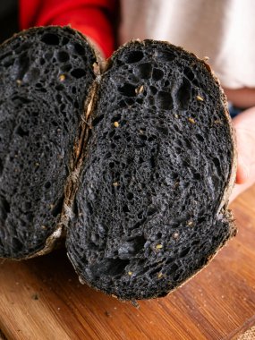 Baker Hand sunar ev yapımı taze pişmiş kömürlü ekşi ekmek. Kırıntılar içeride gösteriliyor