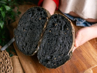 Baker Hand sunar ev yapımı taze pişmiş kömürlü ekşi ekmek. Kırıntılar içeride gösteriliyor