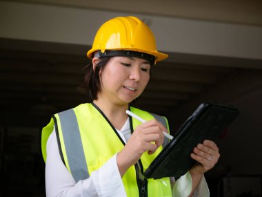 Fabrika kadın işçileri veya teknisyenleri İnşaat mühendisi veya Mimarlık proje yönetimi iş yerinde tableti kullanarak.