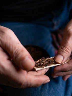 Kurutulmuş tütünle sarılmış sigara hazırlıyorum..