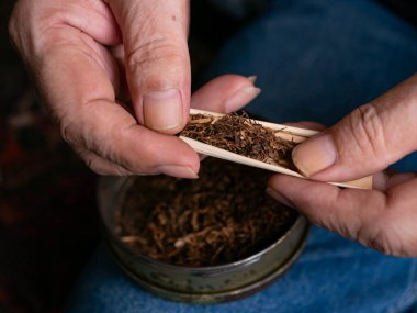 Kurutulmuş tütünle sarılmış sigara hazırlıyorum..