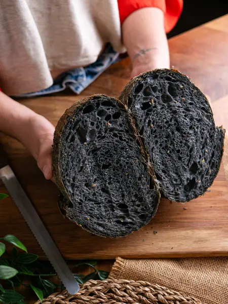 Baker Hand sunar ev yapımı taze pişmiş kömürlü ekşi ekmek. Kırıntılar içeride gösteriliyor