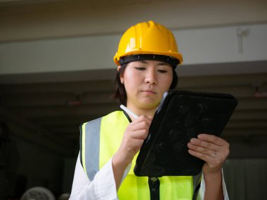 Fabrika kadın işçileri veya teknisyenleri İnşaat mühendisi veya Mimarlık proje yönetimi iş yerinde tableti kullanarak.