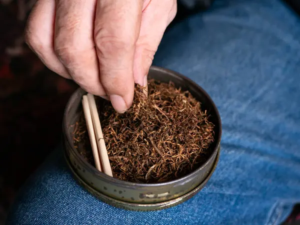 Kurutulmuş tütünle sarılmış sigara hazırlıyorum..