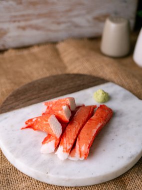 Yengeç çubuğu surimi beyaz tabakta wasibi ile.