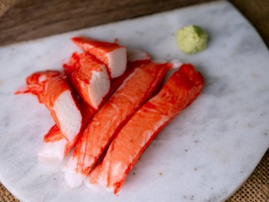 Yengeç çubuğu surimi beyaz tabakta wasibi ile.