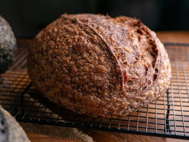 Bir somun taze ekşi ekmek. Ciabatta ekmeği ahşap masaya dizilmiş.