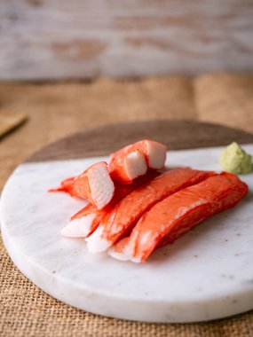 Yengeç çubuğu surimi beyaz tabakta wasibi ile.