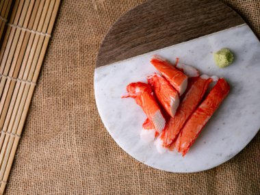 Yengeç çubuğu surimi beyaz tabakta wasibi ile.
